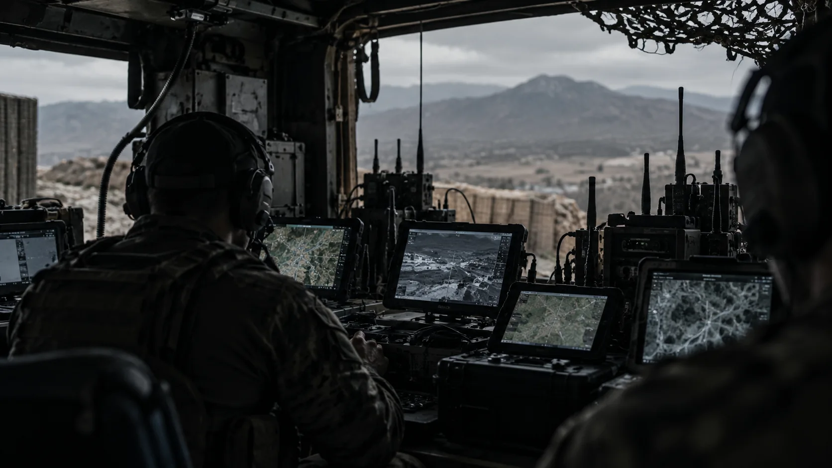 Tactical team working from rugged radio and sensor consoles at a forward observation position